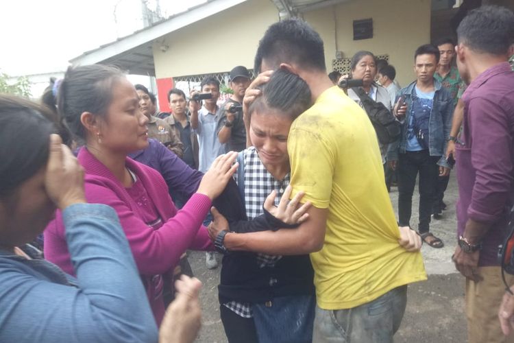 Yanti Zidemi saudara kandung MZ (24) Vikaris yang tewas menjadi korban pembunuhan di Sungai Baung, Kabupaten OKI,Sumatera Selatan menangis haru dipelukan eluarganya, saat jenazah korban tiba di Rumah Sakit (RS) Bhayangkara Palembang, Selasa (26/3/2019).