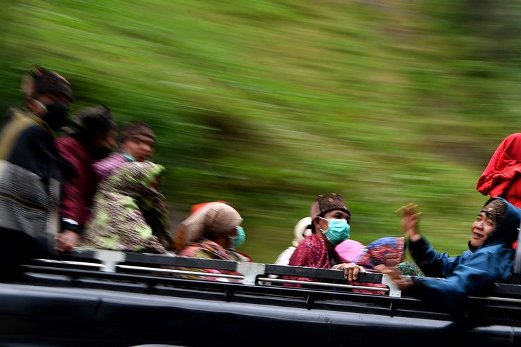 Masyarakat Suku Tengger dengan mengenakan masker berada di mobil bak terbuka menuju kawasan Gunung Bromo untuk melaksanakan perayaan Yadnya Kasada, Probolinggo, Jawa Timur, Senin (6/7/2020). Perayaan Yadnya Kasada merupakan bentuk ungkapan syukur masyarakat Suku Tengger dengan melarung sesaji berupa hasil bumi dan ternak ke kawah Gunung Bromo.