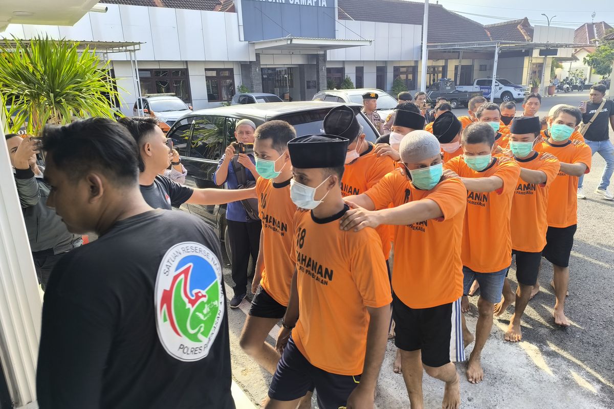 Para Tersangka Narkoba digiring dari menuju ruang tahanan Polres Pamekasan menggunakan dan dijaga personil bersenjata laras panjang, Kamis (19/6/2025)