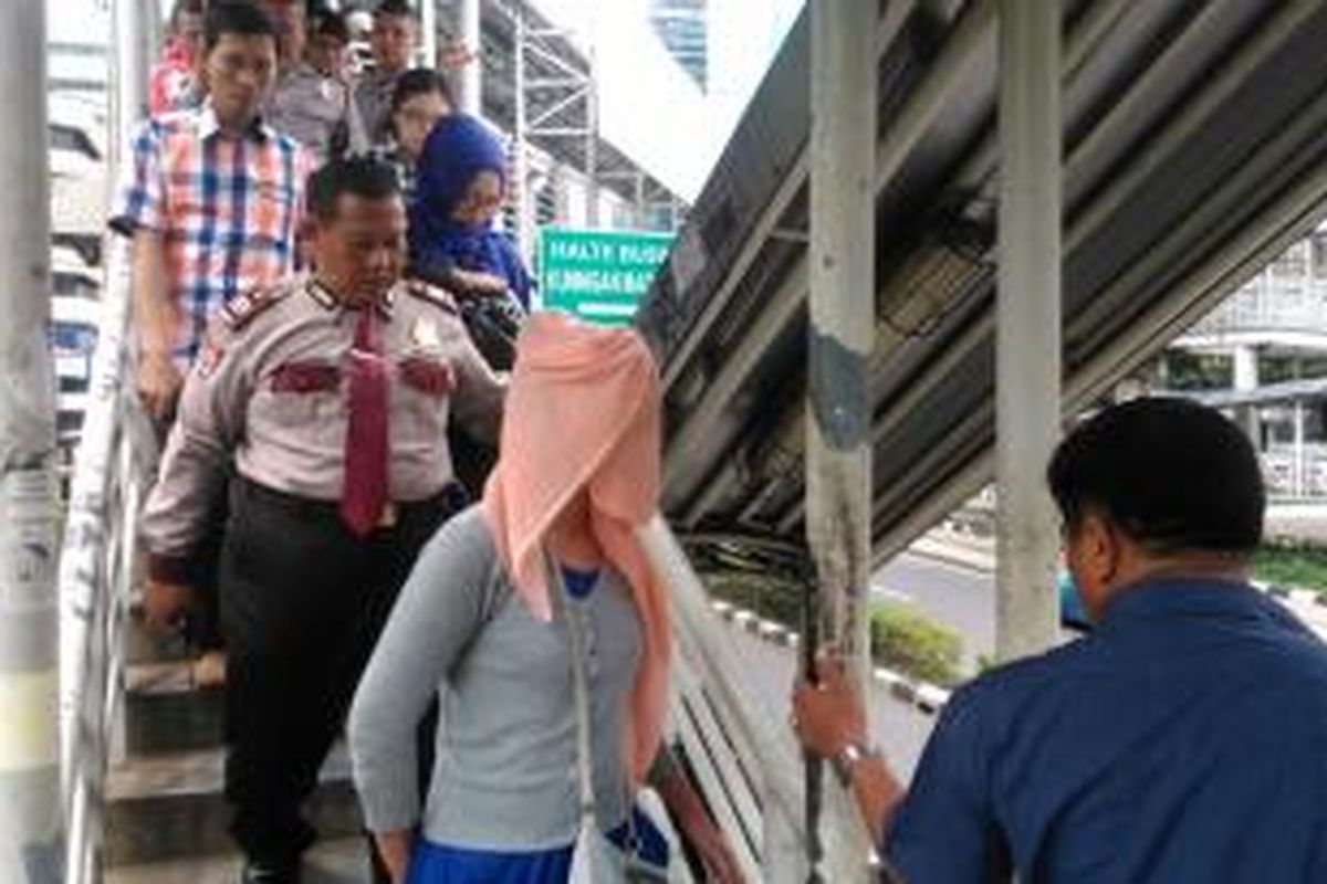 Petugas keamanan dari kepolisian dan TNI berupaya membujuk turun perempuan muda yang diduga hendak loncat dari JPO Kuningan Madya, Kuningan, Jakarta Selatan, Jumat (24/4/2015).