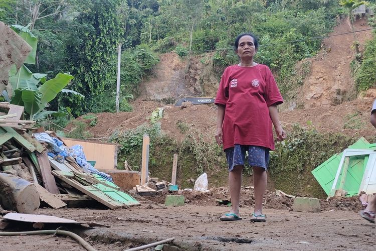 Jumini (65) di tengah puing rumah yang han ur akibat tanah longsor di Pedukuhan Plampang II, Kalurahan Kalirejo, Kapanewon Kokap, Kabupaten Kulon Progo, Daerah Istimewa Yogyakarta, Jumat (1/6/2022) malam.