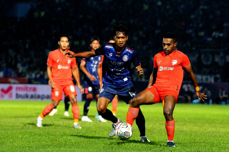 Pemain Arema FC Jayus Hariono menjaga pemain Borneo FC Terens Puhiri saat pertandingan leg pertama Final Piala Presiden 2022 yang berakhir dengan skor 1-0 di Stadion Kanjuruhan Kepanjen, Kabupaten Malang, Kamis (14/7/2022) malam.