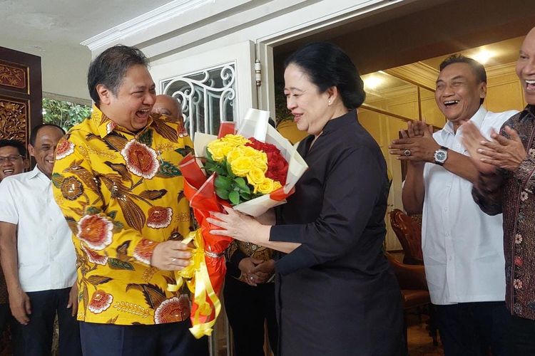 Ketua Umum Partai Golkar Airlangga Hartarto memberikan buket bunga berwarna merah dan kuning kepada Ketua DPP PDI-P Puan Maharani seusai pertemuan keduana di kediaman Airlangga, Kebayoran Baru, Jakarta, Kamis (27/7/2023) sore.