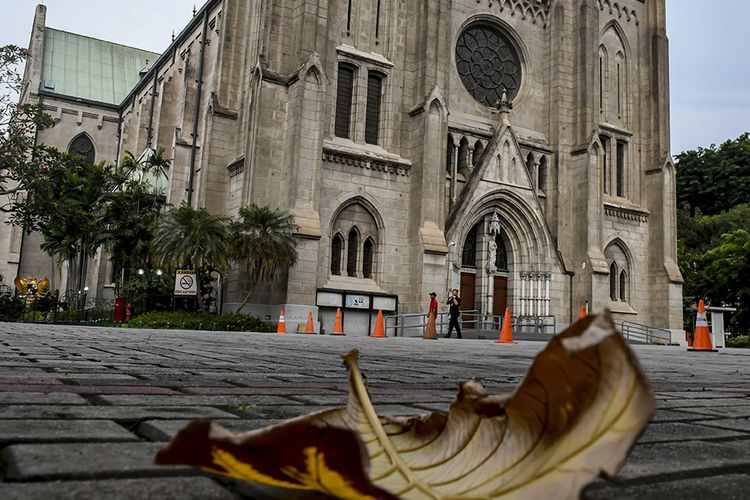 Warga melintas di depan pintu Gereja Katedral, Jakarta, Minggu (5/4/2020). Setelah Kemenkes resmi merilis Peraturan Menteri Kesehatan No.9 Tahun 2020 tentang Pembatasan Sosial Berskala besar (PSBB) dalam Rangka Perception Penanganan COVID-19, bentuk ibadah gereja dilakukan secara live streaming melalui media sosial, termasuk rangkaian ibadah paskah yang akan jatuh mulai Kamis (9/4/2020) hingga Minggu (12/4/2020).