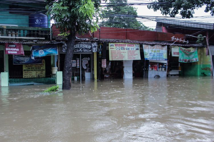 Suasana Jalan Raya Pondok Gede, Kramat Jati, Jakarta Timur, Selasa (25/2/2020) yang terendam banjir. Banjir di kawasan tersebut sudah terjadi pukul 04.00 WIB.