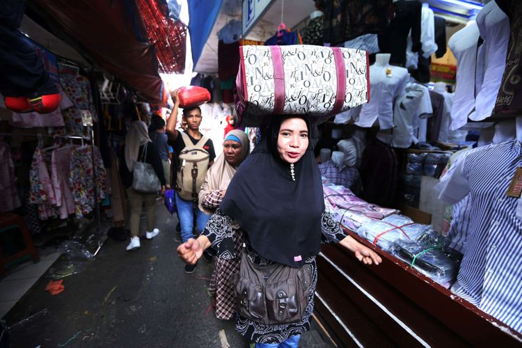 Sejumlah warga usai berbelanja di Pasar Tanah Abang, Jakarta, Senin (4/6/2018). Jelang hari Raya Idul Fitri 1439 Hijriah sejumlah warga mulai memadati pasar Tanah Abang untuk membeli pakaian untuk dijual kembali atau digunakan.