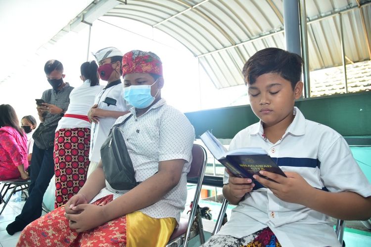 Salah satu siswa beragama Hindu mengikuti tes hafalan kitab suci sebagai syarat PPDB jalur prestasi penghafal kitab suci di Kantor Kemenag Surabaya, Rabu (9/6/2021).