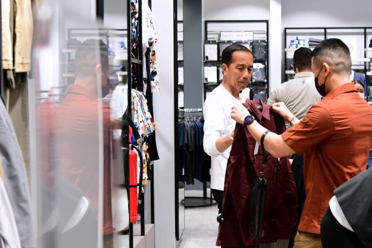 Presiden Joko Widodo ketika melihat-lihat kemeja di toko pakaian lokal, Executive, saat mengunjungi pusat perbelanjaan Grand Indonesia di Jakarta Pusat pada Minggu (15/1/2023) malam.