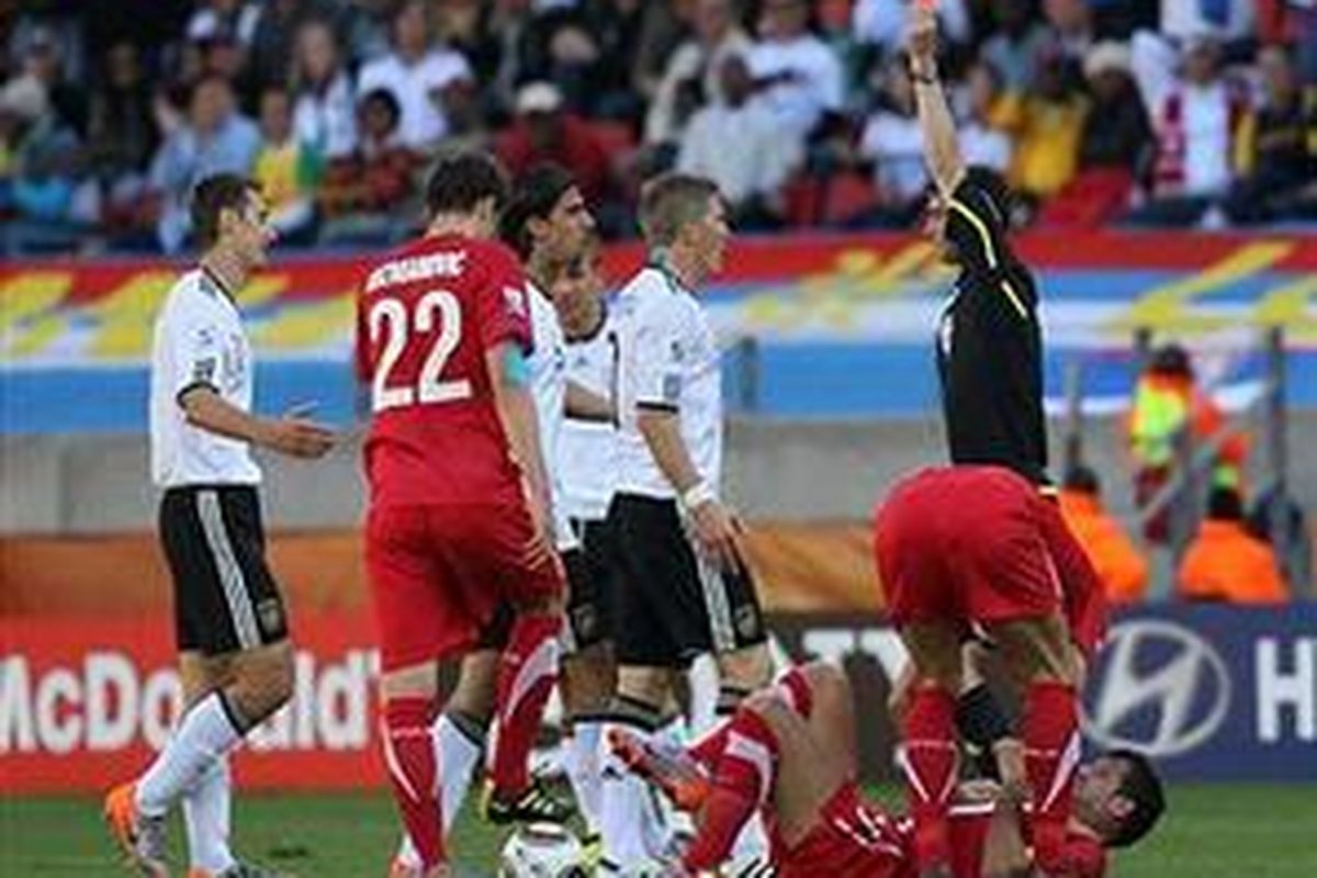 Penyerang Jerman, Miroslav Klose (kiri) mendapat kartu kuning kedua, setelah melanggar pemain Serbia, Dejan Stankovic, pada babak penyisihan grup Piala Dunia 2010 Afrika Selatan, Jumat (18/6/2010).