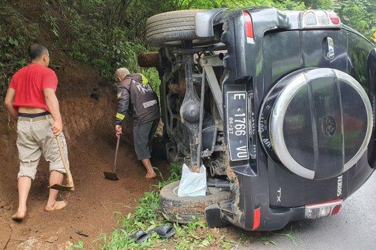 Sejumlah warga saat menutup saluran air untuk mengevakuasi mobil yang terguling di jalur Cikebo, Kecamatan Maja, Kabupaten Majalengka, Selasa (30/4/2024). 
