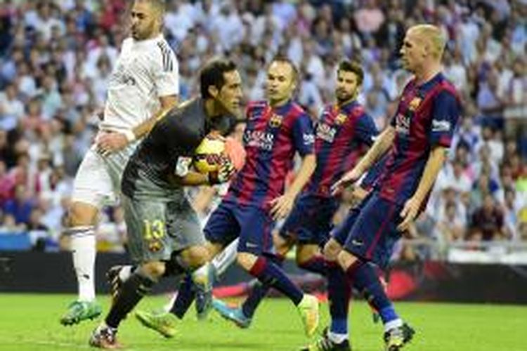 Kiper Barcelona Claudio Bravo (kedua dari kiri) memenangi perebutan bola dengan penyerang Real Madrid Karim Benzema (kiri), pada pertandingan Primera Division, di Santiago Bernabeu, Sabtu (25/10/2014).