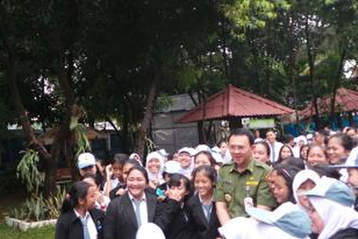 Gubernur DKI Jakarta Basuki Tjahaja Purnama berfoto bersama siswa siswi di SMK Negeri 27, Sawah Besar, Jakarta Pusat, Senin (13/4/2015). Mereka berfoto bersama sebelum melaksanakan Ujian Nasional (UN).