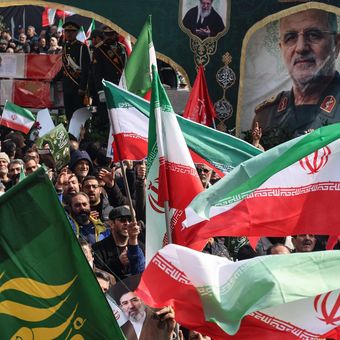 Warga Iran mengibarkan bendera negara saat menghadiri pemakaman para komandan Korps Garda Revolusi Iran (IRGC) yang tewas dalam serangan Amerika Serikat-Israel, di Lapangan Enghelab, Teheran, 11 Maret 2026.