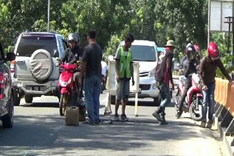 Sejumlah petugas tengah memperbaiki jalur mudik Trans Sulawesi. Agar bisa dilalui pemudik dengan aman, petugas mengebut perbaikan tersebut. 