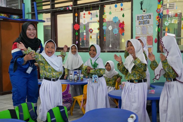 Terlihat para siswi perempuan sedang bermain bersama dalam kegiatan ?KPI Goes to School?. Program yang dijalankan oleh PT Kilang Pertamina Internasional (KPI) ini bertujuan memperkenalkan anak-anak dengan konsep dasar energi, keberlanjutan, dan teknologi melalui pendekatan interaktif.