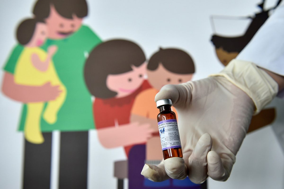 Seorang petugas medis memegang botol yang berisi vaksin measles-rubella (MR) di sebuah pos kesehatan di Banda Aceh, Rabu (19/9/2018). Terkait polemik kehalalan imunisasi MR, Majelis Permusyawaratan Ulama Aceh merujuk pada fatwa MUI memutuskan penggunaan vaksin MR di Aceh diperbolehkan jika dalam kondisi darurat dan tidak memaksakan bagi masyarakat yang tidak setuju anaknya diimunisasi.