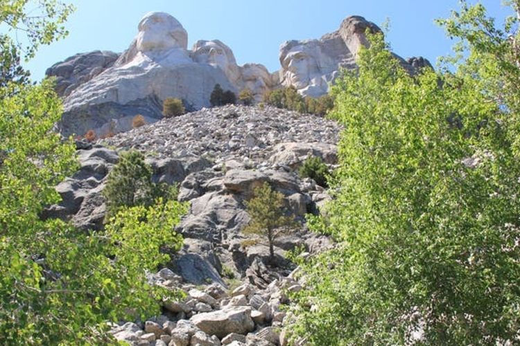 Rushmore dilihat dari bawah tampak bangunan dengan jalanan yang terjal dan banyak bebatuan 