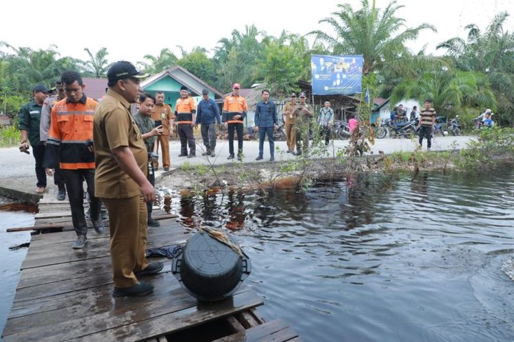 Wakil Bupati Siak ketika meninjau banjir akibat parit di depan rumah warga yang meluap di Kecamatan Sabak Auh. 