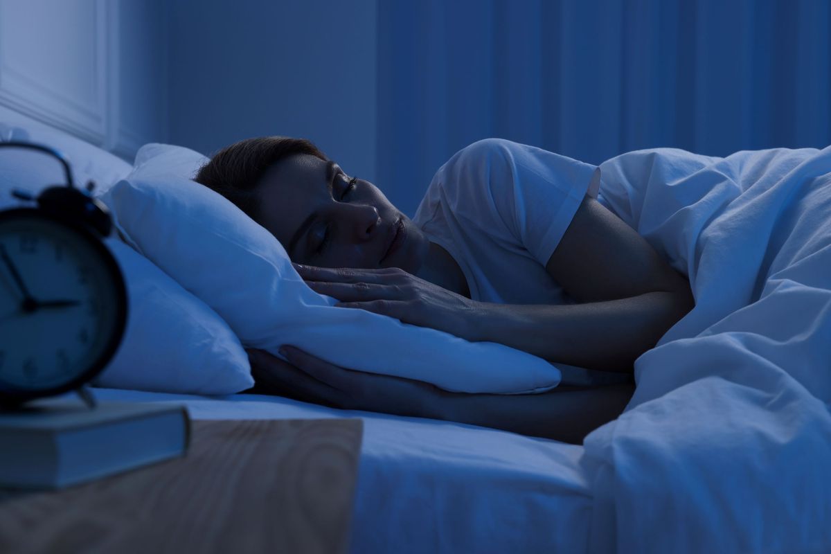 Ilustrasi seorang perempuan sedang tidur nyenyak di malam hari.