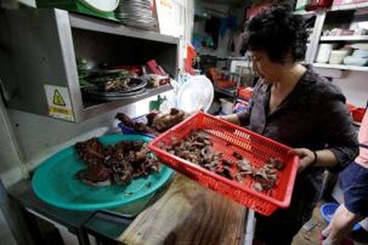 Oh Keum-il (58), pemilik restoran Daegyo, Seoul, tengah mempersiapkan salah satu sajian yang dibuat dari daging anjing. Restoran milik Oh yang berdiri pada 1981 di masa jayanya menjual 700 mangkok daging anjing rebus setiap hari. Namun, kini warga Korea Selatan sudah semakin meninggalkan daging anjing sebagai makanan favorit.