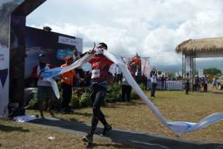 Pelari pertama dalam lomba lari ultra Lintas Sumbawa 320K, Matheos Berhitu (44), berlari memasuki garis finis di Doro Ncanga, Kabupaten Dompu, Nusa Tenggara Barat, Sabtu (16/4/2016) sore. 