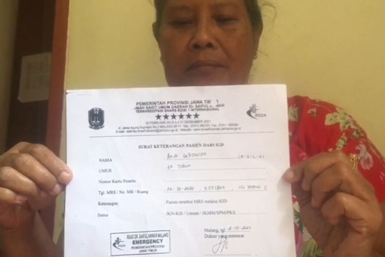 Keluarga korban meninggal tragedi Kanjuruhan Andi Setiawan menunjukkan surat keterangan pasien dari IGD, RSSA Kota Malang. 
