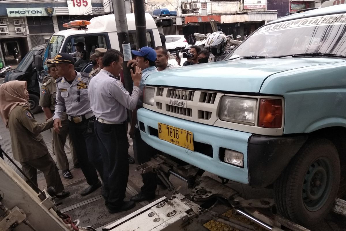 Dishub Jaktim derek angkot yang parkir di atas trotoar Jatinegara Barat, Jakarta Timur, Rabu (25/4/2018)