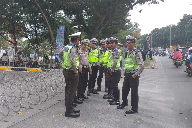 Petugas kepolisian sedang berada di depan gerbang Kantor DPRD Riau, yang telah dipasang kawar berduri untuk pengamanan aksi unjuk rasa mahasiswa di Pekanbaru, Riau, Senin (30/9/2019).