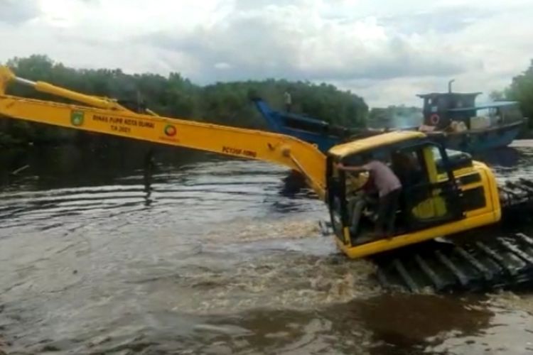 Eskavator amfibi melakukan pengerukan di hilir Sungai Dumai untuk meminimalisir dampak banjir di permukiman warga di Kota Dumai, Riau, Senin (1/11/2021).