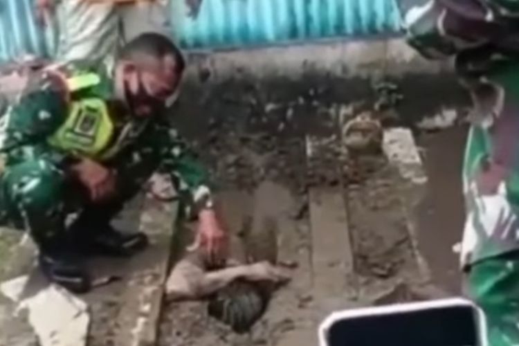 Tangkapan layar seorang pemuda yang nekat mengubur diri hidup-hidup di TPU di Kota Tegal tengah dibujuk aparat untuk dievakuasi pada Rabu (30/12/2020) lalu. (ist)