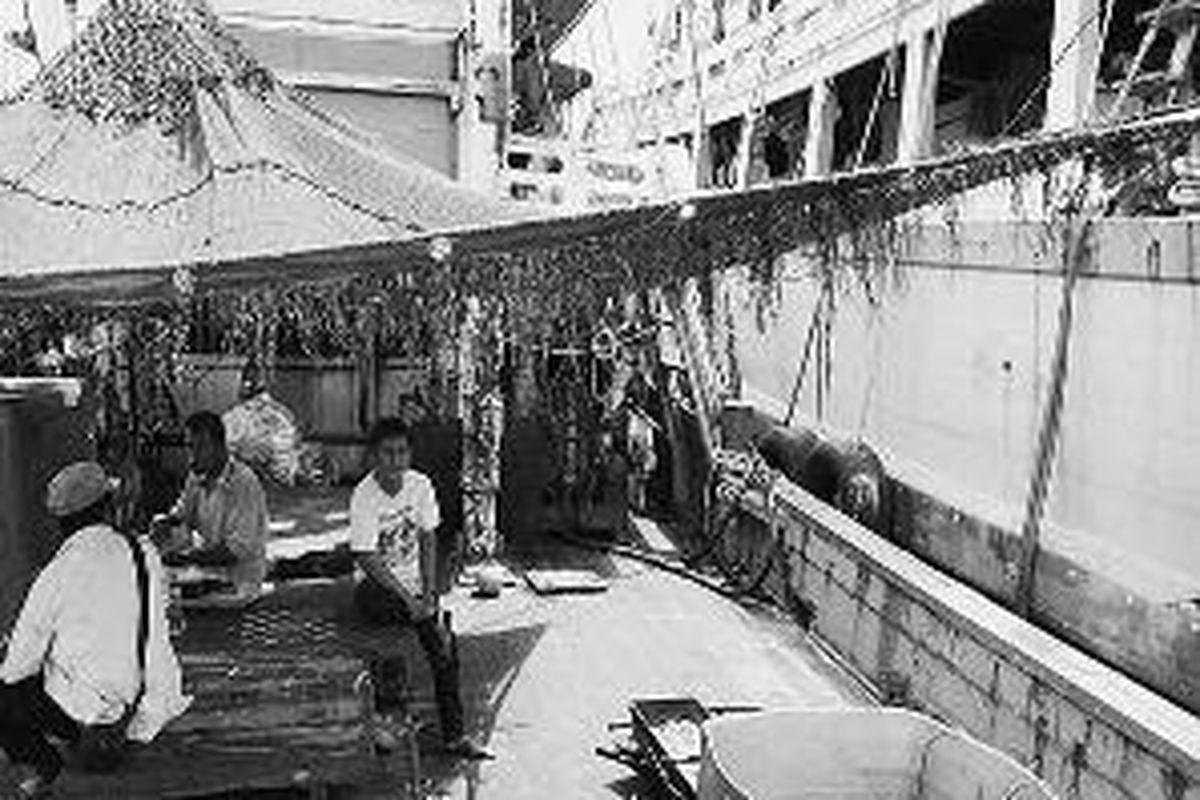 Nelayan Thailand hampir dua tahun menanti putusan pengadilan perikanan di Tual, Maluku, atas kapal-kapal tempat mereka bekerja yang diduga melakukan pelanggaran. Selama hampir dua tahun mereka bertahan hidup dengan menjadi buruh angkut, bangunan, dan kebun sayur. Sebagian di antara mereka tampak duduk-duduk di perahu, Selasa (27/10).