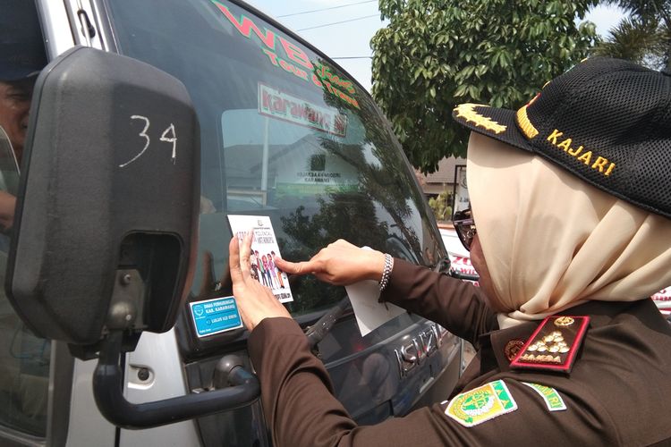 Kepala Kejari Karawang Rohayatie menempelkan stiker imbauan anti korupsi di Jalan Jaksa Agung R. Soeprapto, Nagasari, Karawang, Senin (9/12/2019).