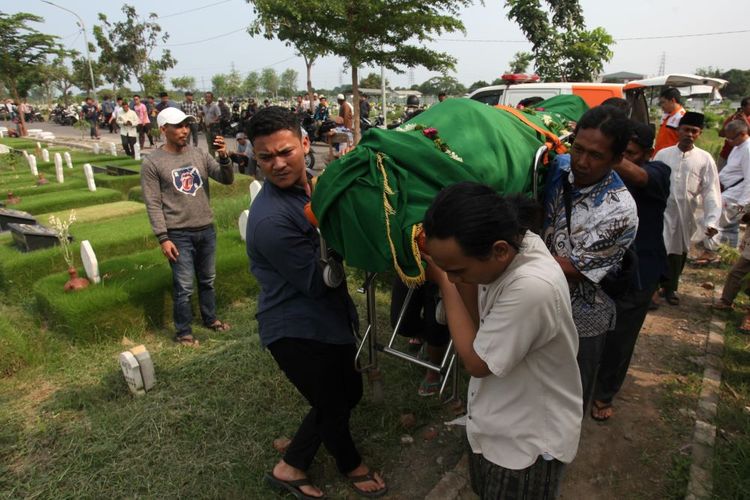 Warga menggotong jenazah Joko Budiono (51) untuk dimakamkan di Tempat Pemakaman Umum (TPU) Keputih, Surabaya, Jawa Timur, Jumat (16/2/2024). Joko Budiono (51) yang merupakan Ketua Kelompok Penyelenggara Pemungutan Suara (KPPS) di Tempat Pemungutan Suara (TPS) 42, Kelurahan Ngagel Rejo, Kecamatan Wonokromo, Surabaya tersebut meninggal dunia usai dirawat karena sakit di RSUD Dr Soetomo yang sebelumnya sempat tak sadarkan diri saat bertugas di TPS 42 di Pemilihan Umum (Pemilu) 2024 pada Rabu (14/2/2024). ANTARA FOTO/Didik Suhartono/foc.