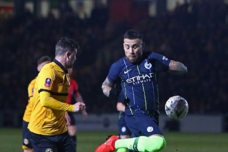 Nicolas Otamendi mengamankan bola dari kejaran Padraig Amond pada pertandingan Newport County vs Manchester City di Rodney Parade dalam babak 16 besar Piala FA, 16 Februari 2019. 