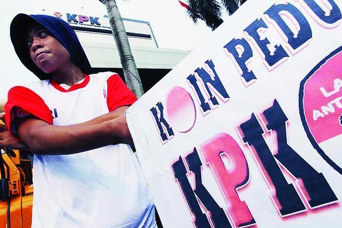 Simpatisan Laskar Antikorupsi menggalang dana dari pengguna jalan di depan Gedung Komisi Pemberantasan Korupsi, Jakarta, Rabu (27/6). Koin Peduli KPK tersebut akan diserahkan ke KPK untuk biaya pembangunan Gedung KPK yang baru.