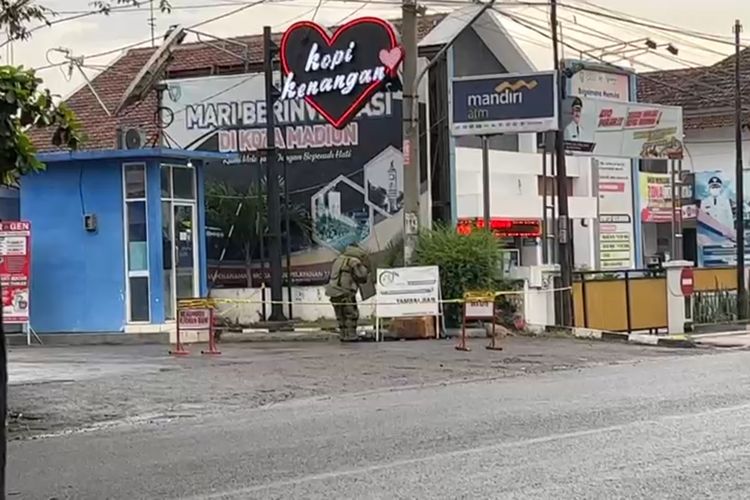 CEK-Petugas Gegana Brimobda Polda Jatim sementara mengecek isi kardus yang mencurigakan.Kardus sudah berada di pojok SPBU Jalan DI Pandjaitan Kota Madiun sejak kemarin. 