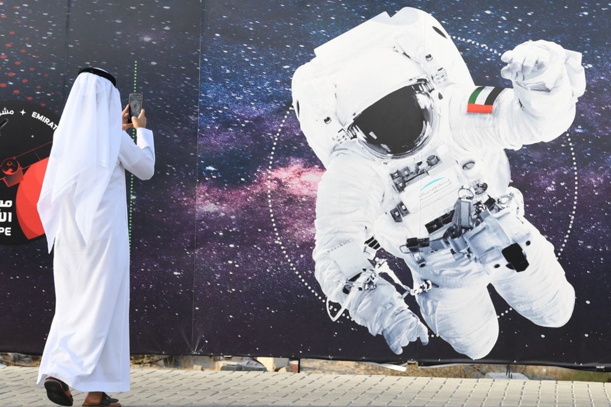 Foto ini diambil pada 25 September 2019. Seorang pria mengambil gambar ilustrasi yang menggambarkan seorang astronot dengan bendera nasional Uni Emirat Arab (UEA) di Mohammed Bin Rashid Space Center (MBRSC) di Dubai. Misi luar angkasa Arab pertama ke Mars, rencananya akan diluncurkan bulan depan untuk mempelajari atmosfer Planet Merah. Misi ini dirancang untuk menginspirasi kaum muda di kawasan itu dan membuka jalan bagi terobosan ilmiah, kata para pejabat pada 9 Juni 2020. (Foto oleh KARIM SAHIB / AFP)