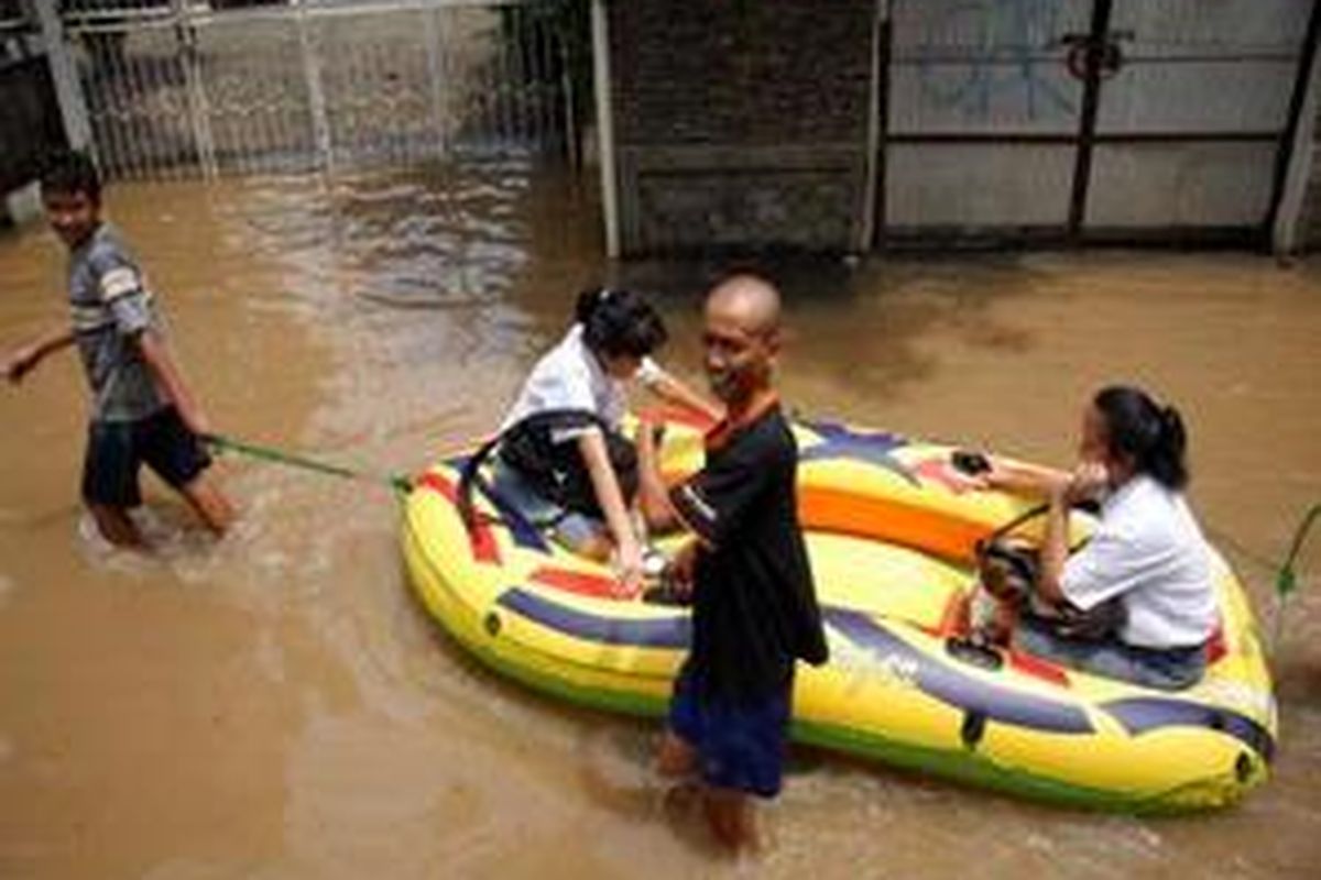 Para siswa menumpang perahu karet menuju sekolah mereka di Kebayoran Baru.