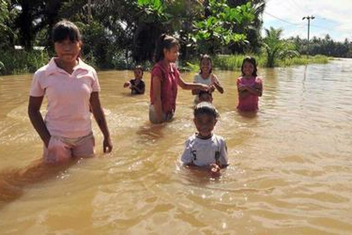Anak-anak bermain air saat banjir di Kecamatan Sei Rampah, Kabupaten Serdang Bedagai, Sumatera Utara, Rabu (7/11/2012).