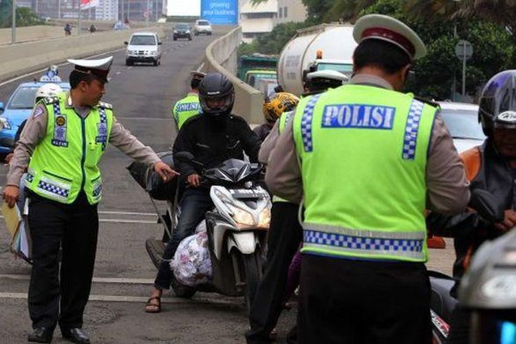 Polisi lalu lintas merazia para pengendara sepeda motor yang nekat melintasi JLNT Kampung Melayu-Tanah Abang di kawasan Karet, Jakarta Pusat, Selasa (28/1/2014). Puluhan pengendara sepeda motor terjaring dalam razia yang dilakukan untuk menekan tingkat kecelakaan. Seharusnya pemotor dilarang melintas JLNT tersebut. 