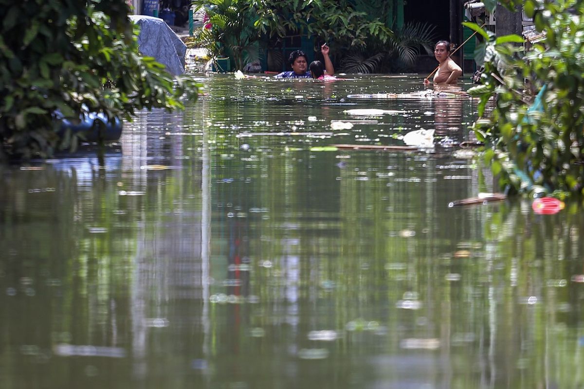 Warga berjalan di tengah banjir di Total Persada, Periuk, Kota Tangerang, Banten, Senin (22/2/2021). Memasuki hari ketiga, kawasan tersebut masih terendam banjir hingga setinggi 2,5 meter akibat luapan Kali Leduk. ANTARA FOTO/Fauzan/aww.