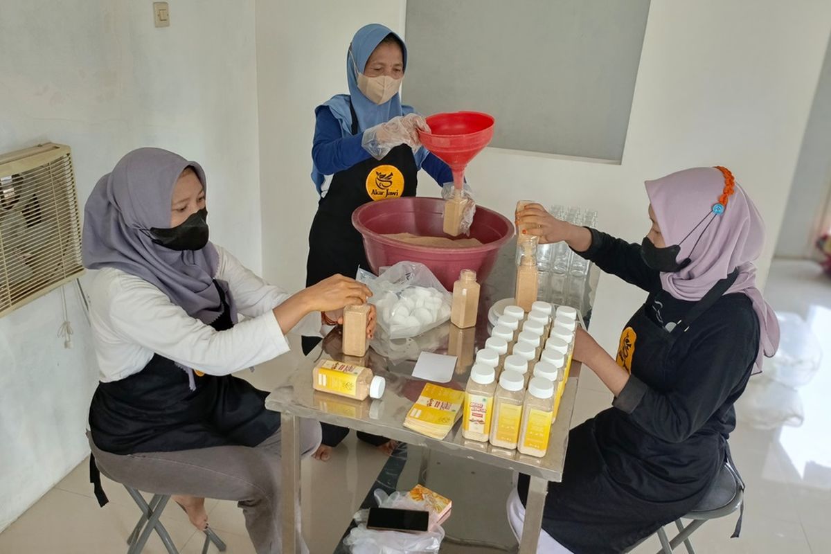 Salamah bersama karyawan sedang mengemas jamu herbal dengan jenama Akar Jawi