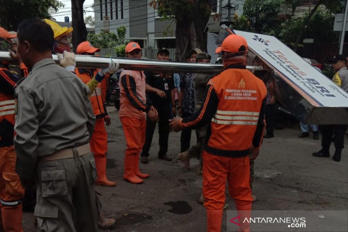 Petugas Sarana dan Prasarana Umum mengangkut papan reklame yang dipotong oleh Satpol PP kecamatan Cempaka Putih dalam razia reklame ilegal di Rawasari, Cempaka Putih, Jakarta Pusat, Selasa (13/2/2020). 
