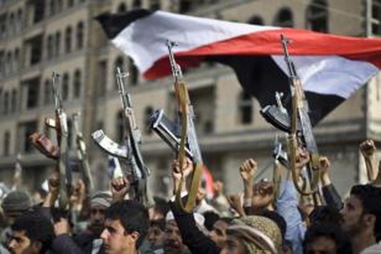 Pemberontak Syiah, yang dikenal sebagai Houthi, mengangkat senjata mereka saat aksi protes terhadap serangan udara Saudi Arabia di Sanaa, Yaman, 10 April 2015.