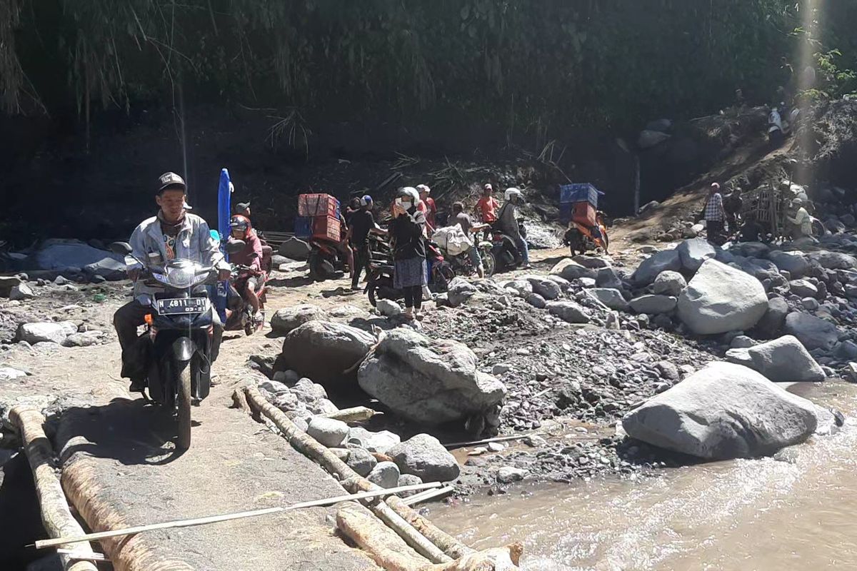 Warga melintas di jembatan darurat Sungai Glidik, Selasa (11/7/2023)