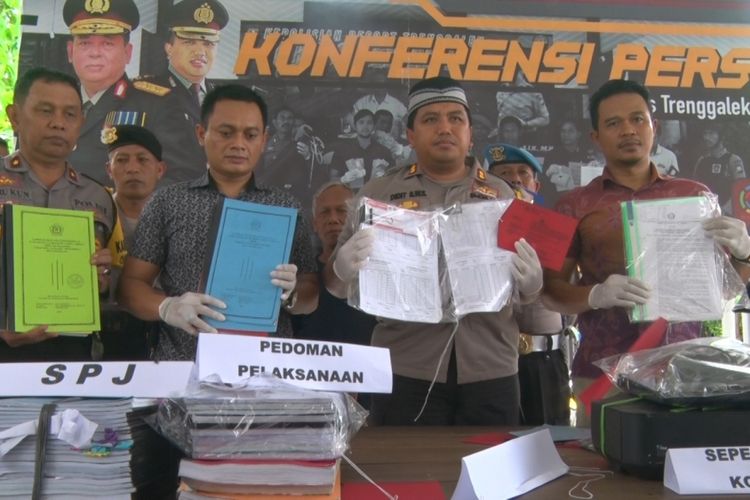 Kapolres Trenggalek AKBP Didit Bambang Wibowo (berpeci) didampingi jajarannya menunjukkan barang bukti berkas serta dokumen tindak pidana korupsi yang dilakukan oleh pengelola Yayasan MI Yapendawa di Desa Bendo, Kecamatan Pogalan, Trenggalek, Jawa Timur, Jumat (21/12/2018). 