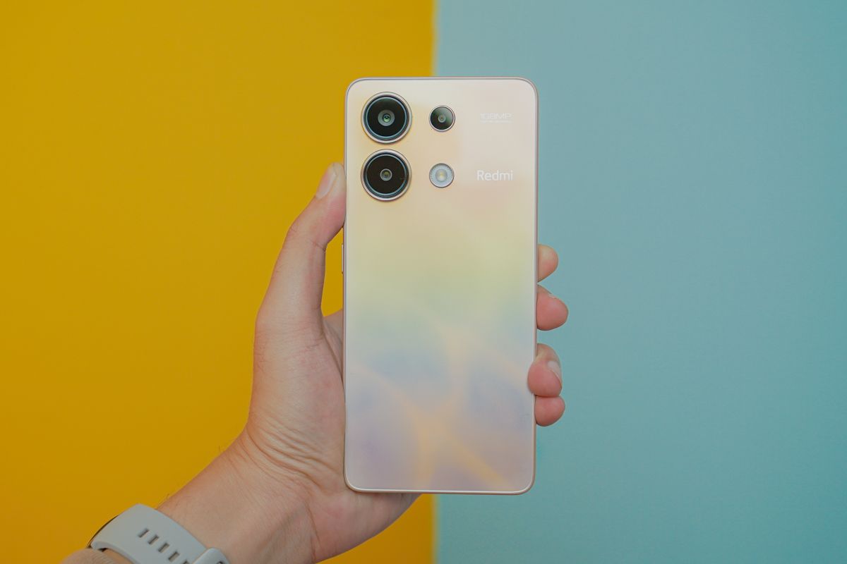 Xiaomi Redmi Note 13 4G varian warna Ocean Sunset memiliki punggung berkelir silver yang memantulkan gradasi aneka warna seperti pelangi. 