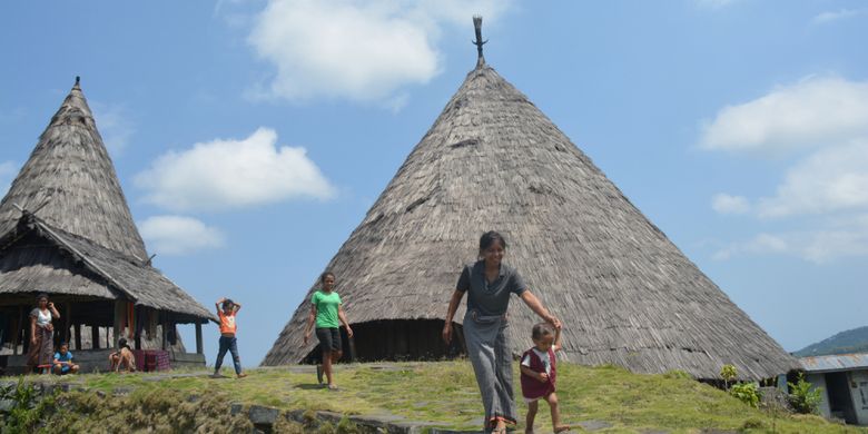 Warga Kampung tradisional Todo melintasi di depan Mbaru Niang Todo, Oktober 2018 lalu. setiap hari warga di kampung adat Todo itu menjual kain tenun bermotif Todo di Manggarai, Flores, NTT. 