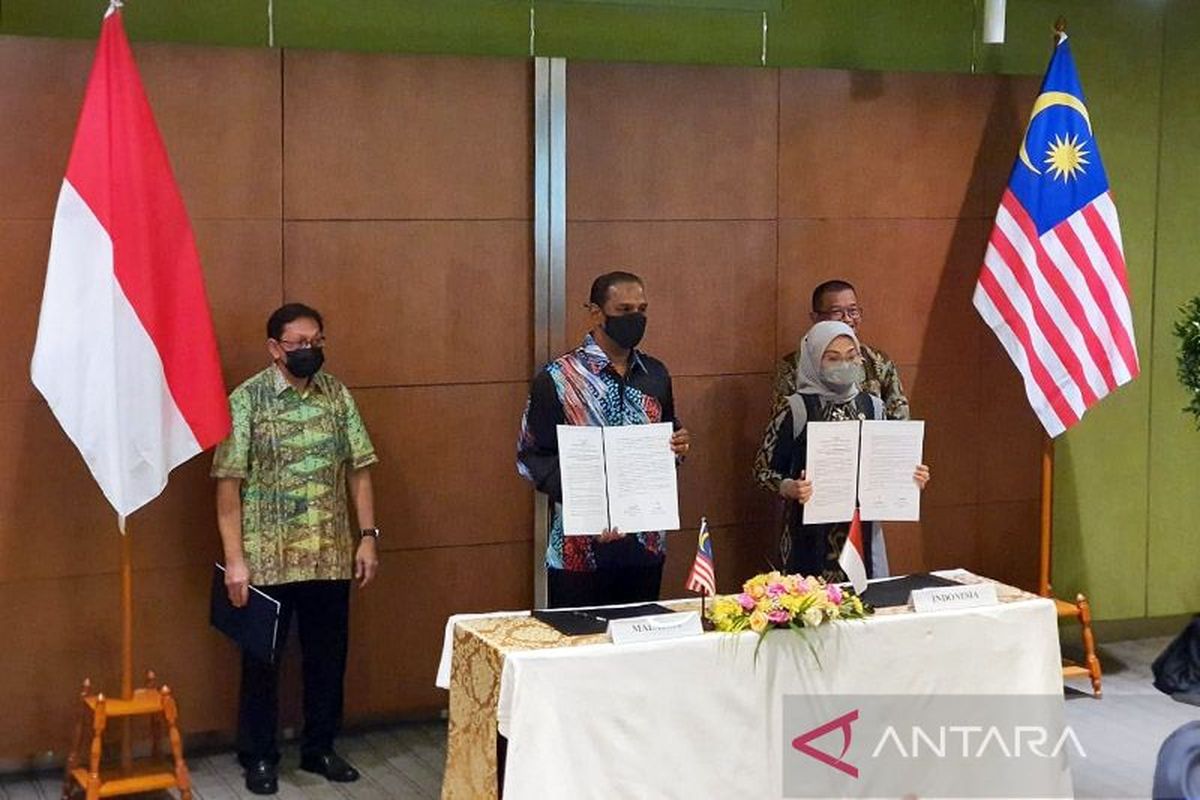 Indonesia's Manpower Minister Ida Fauziyah (Front-Right) and Malaysia's Human Resources Minister M. Sarayanan Murugan (Front-Left) signed a joint statement regarding the memorandum of understanding on placement and protection of the Indonesian migrant workers in Malaysia's domestic sector in Jakarta, Thursday, July 28,2022 after the first Joint Working Group (JWG) meeting.