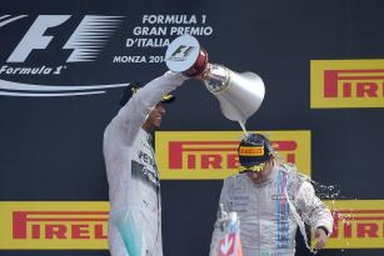 Pebalap Mercedes asal Inggris, Lewis Hamilton (kiri), menyiramkan champagne dari trofi juaranya kepada pebalao Williams asal Brasil, Felipe Massa, di atas podium Sirkuit Monza pada GP Italia, Minggu (7/9/2014). Massa finis ketiga di belakang Nico Rosberg.